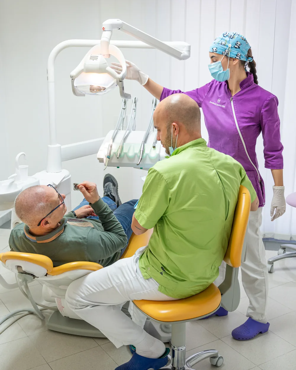 Team della Sardinia Dental Clinic in dialogo con un paziente durante la seduta a Olbia