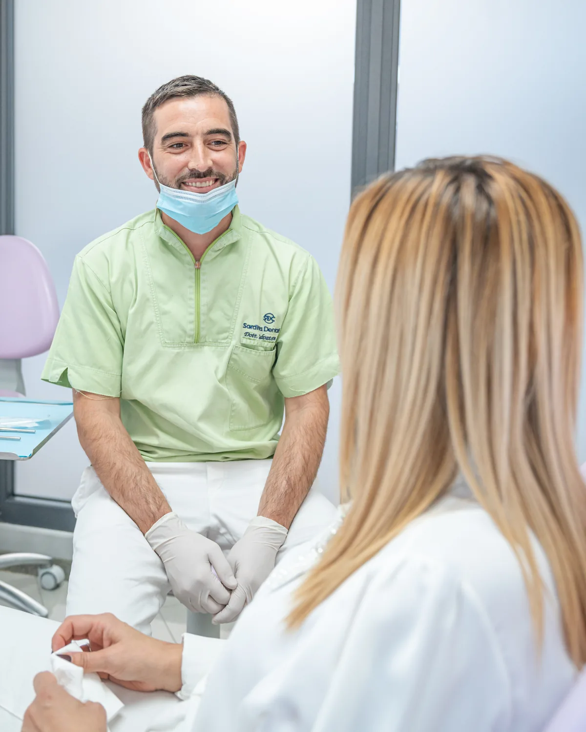 Un professionista della Sardinia Dental Clinic ascolta le domande di una paziente durante il consulto a Olbia