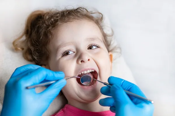Bambina serena durante una visita di odontoiatria pediatrica a Olbia